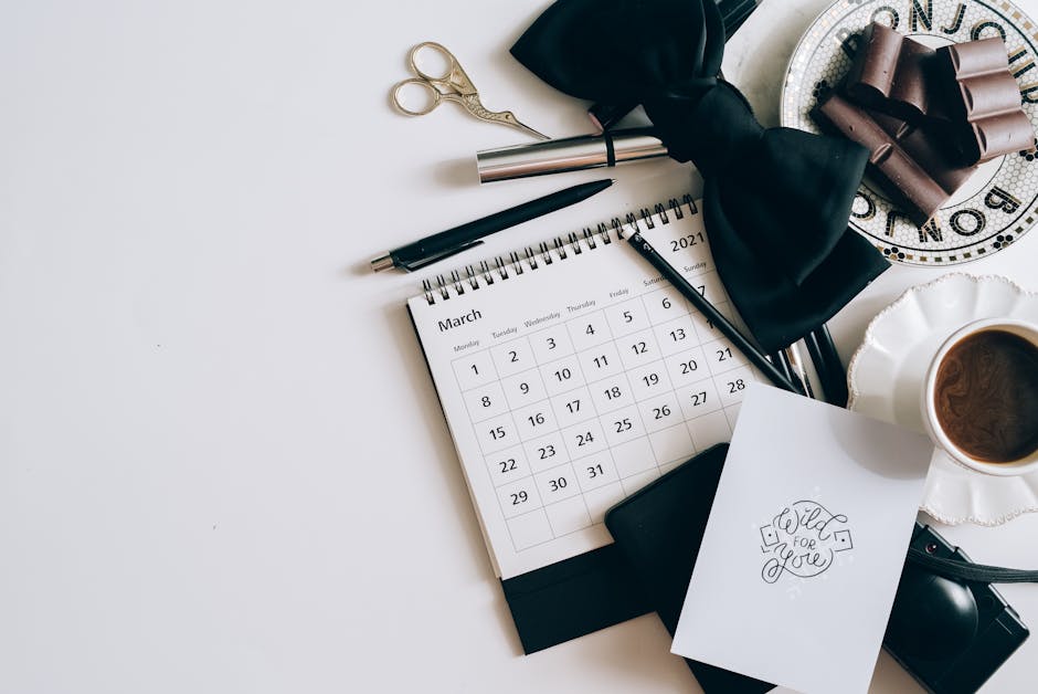Flat lay of a desk with calendar, coffee, and chocolates. Elegant workspace setting.
